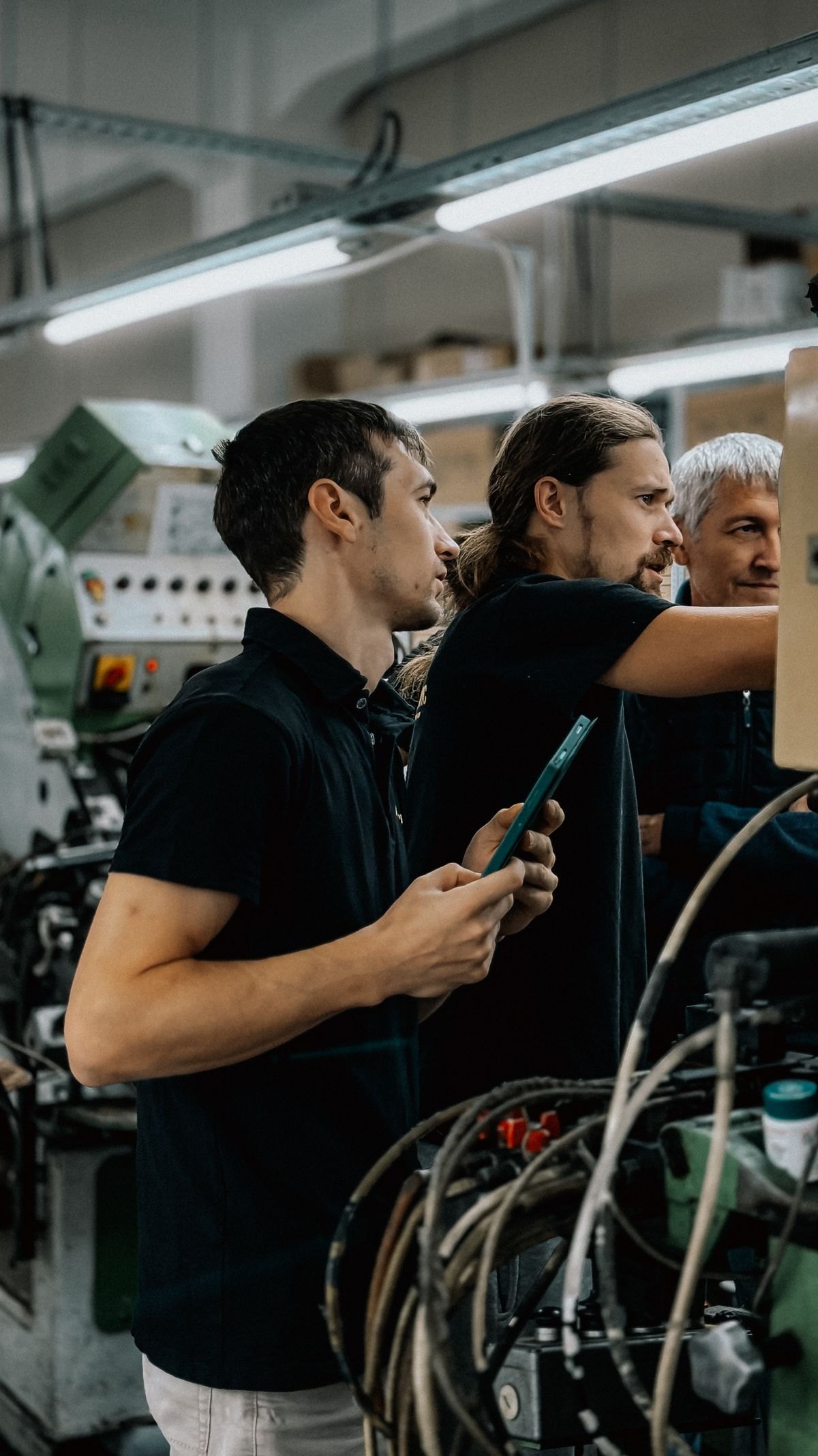 Engineers collaborating on machinery operations inside a modern manufacturing facility