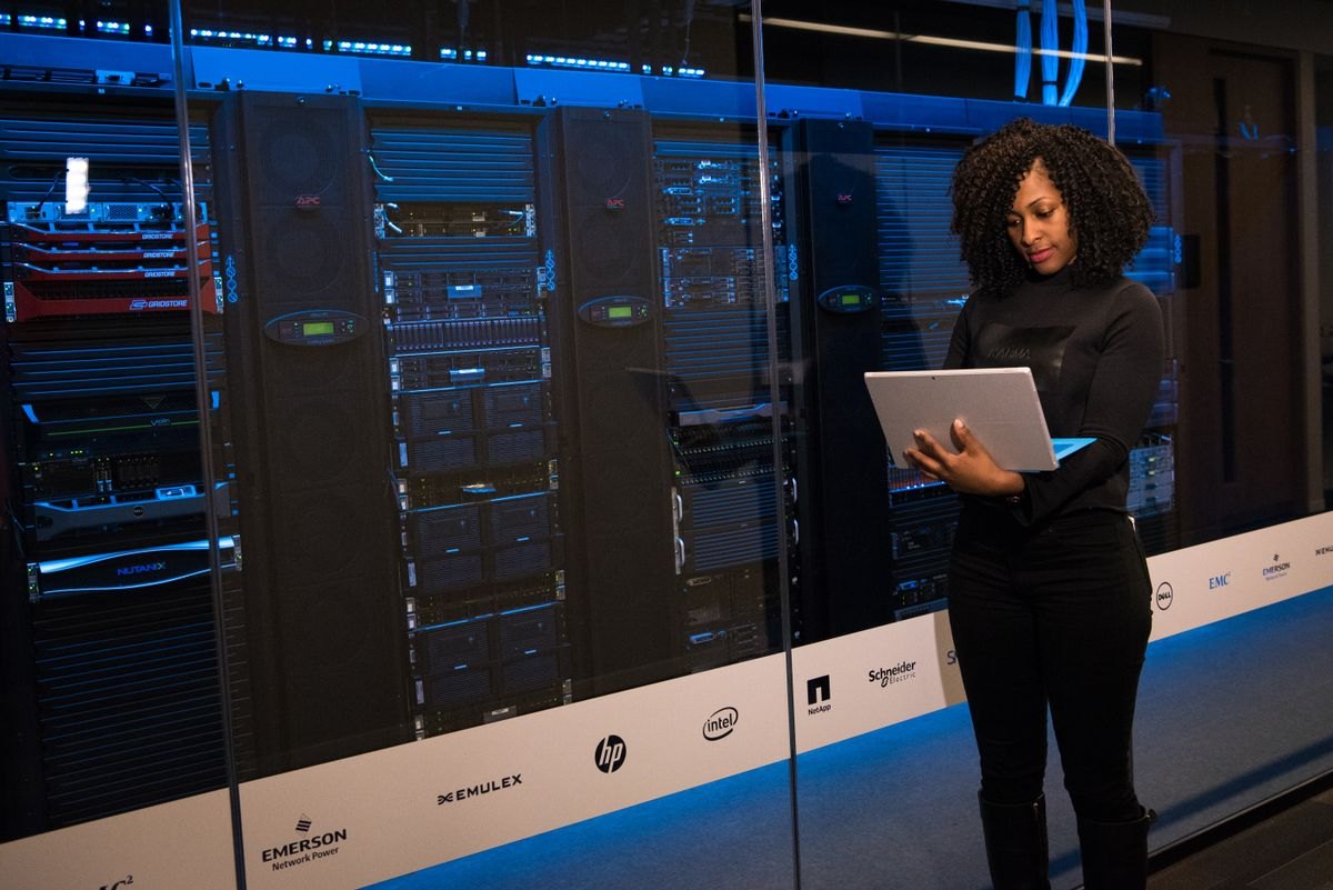 IT professional checking servers in a data centre with a laptop