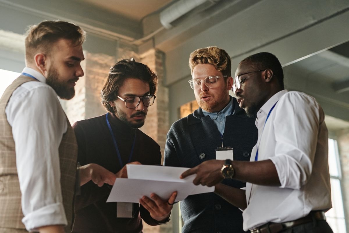 Colleagues reviewing printed process documents together in an office